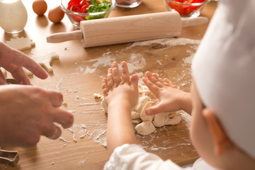 The boy helps parents sculpt from dough. Play with a child. Children's education and the development of motor skills.