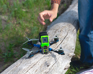 multicolored racing drone on grass background - Powered by Adobe