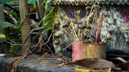 Wilted flowers in a painted can on the stone