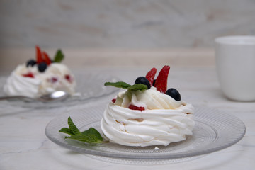 Beautiful Anna Pavlova dessert with mint and berries (strawberries, blueberries) on a white background. Cooking. Photo for menu.