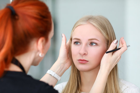Makeup artist looks at symmetry models eyebrows