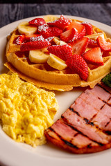 Waffle Breakfast Plate with Bananas, Strawberries and Eggs with Canadian Bacon