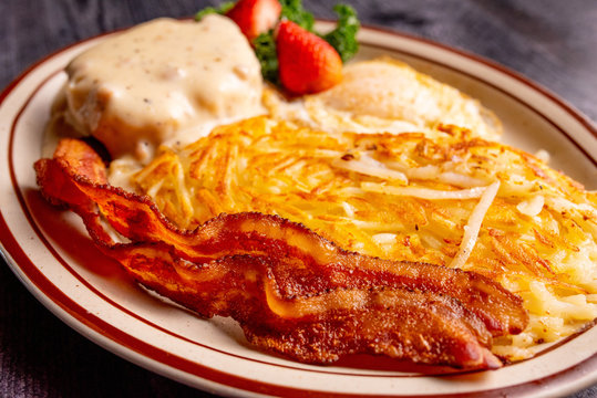 Traditional Breakfast Plate With Bacon, Hash Browns, Egg And Biscuit With Country Gravy