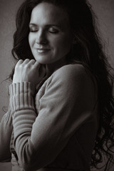 Obraz premium Pretty brunette woman with long curly hair in the shadow