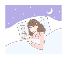 布団の中でスマホを見る不安そうな女性