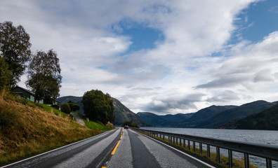 Driving on the Norwegian countryside on the side of a fjord