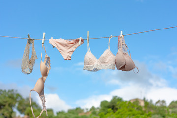 Female underwear is dried on a clothesline in a garden. Selective focus in pastel colors. Washing and care of clothes concept