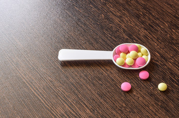 Colored pills on the table. Medical drugs on a dark background. Place for text.