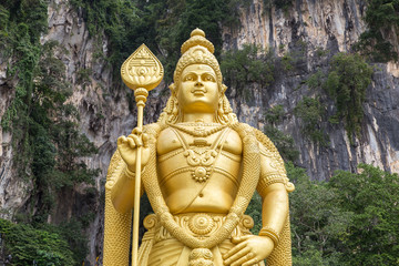 Close view on the huge golden statue of Hindu god Murugan at the entrance of Batu caves complex near Kuala Lumpur, Malaysia