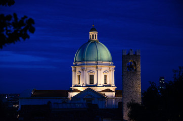 Fototapeta na wymiar Dome of Santa Maria Assunta New Cathedral, Duomo Nuovo Roman Catholic church and Tower of Palazzo del Broletto palace, night evening view, Brescia city historical centre, Lombardy, Northern Italy