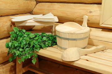 Sauna accessories and fresh birch broom in a corner of the bathhouse. 