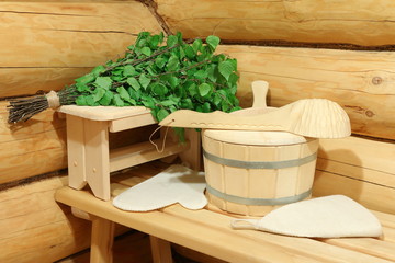 Sauna accessories and fresh birch broom in a corner of the bathhouse. 