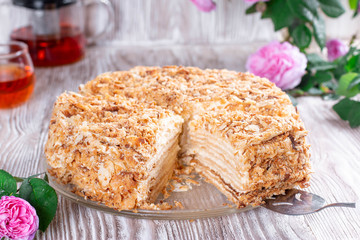Classic Napoleon cake with a cup of tea. Traditional dessert with puff pastry and custard, russian cuisine treat