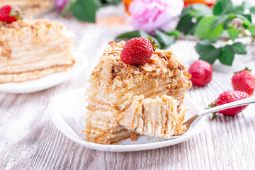 Piece of cake Napoleon on white plate . Russian cuisine, layered cake with pastry cream
