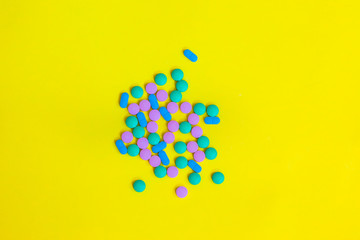 Handful medical pills on a yellow background 