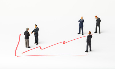 Fototapeta premium Miniature people on paper with painted financial chart.