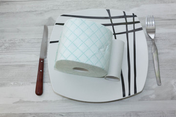 Plate with roll of toilet paper ready to eat