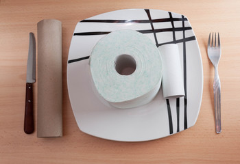 Toilet paper and cardboard food on oak table