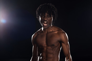 Fototapeta na wymiar sexy aggressive african american man yelling on black with back light