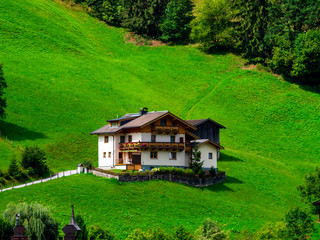 Green hills of an alpine resort in Austria in summer. Small village, hotels and chalets, all in colors. Beautiful terraces and solar panels on the roofs. The proximity of civilization and pure nature.