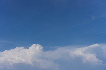 White clouds on a back of blue sky. Clear sky with fluffy light clouds.