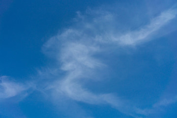 White clouds on a back of blue sky. Clear sky with fluffy light clouds.