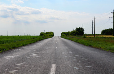 Fototapeta na wymiar An empty asphalt road through the rural landscape.