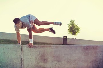 Young attractive man jumping on wall
