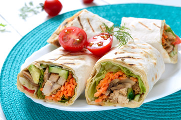 Fresh tortilla wraps with chicken, mushrooms and fresh vegetables. Chicken Mexican burrito. Tasty appetizer. Dishes from pita bread. Healthy food concept
