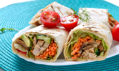 Fresh tortilla wraps with chicken, mushrooms and fresh vegetables. Chicken Mexican burrito. Tasty appetizer. Dishes from pita bread. Healthy food concept
