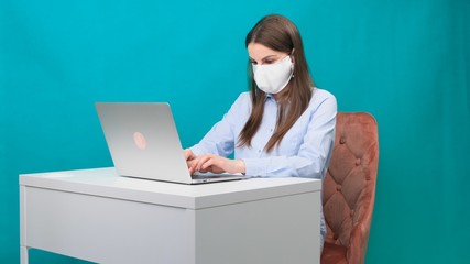 woman working at home with medical mask on face. coronavirus quarantine remote home working concept.