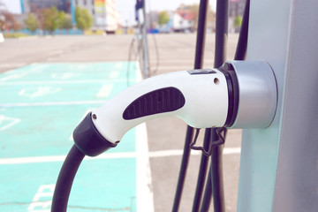 Power supply for electric car charging. Electric car charging station. Close up of the power supply plugged into an electric car being charged.