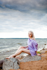 Fototapeta na wymiar blonde girl by the sea / lake