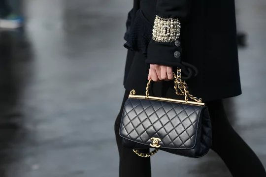 Paris, France – March 3, 2020: Black leather Chanel chain bag - streetstylefw20  Stock Photo