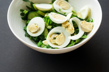 Diet menu. Healthy salad of fresh vegetables - tomatoes, avocado, arugula, egg, spinach and quinoa on a bowl. Flat lay. Top view.