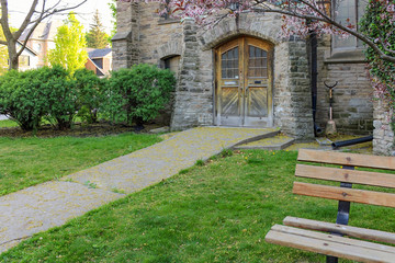 A path covered with yellow flowers leads to an entrance of an old Christian church 