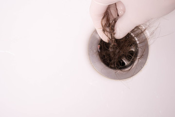 hand cleans the sink in the bathroom, which is clogged with hair