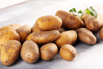 Pile of potatoes lying on wooden boards. Fresh healthy potato