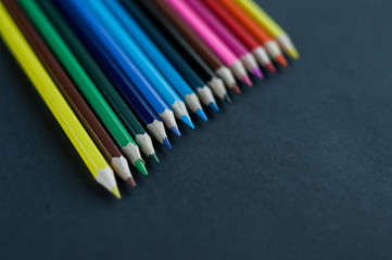 Colored pencils background.Color pencils on dark purple background.Close up. Many different colored pencils on dark purple background.Colorful pencil .Colorfull