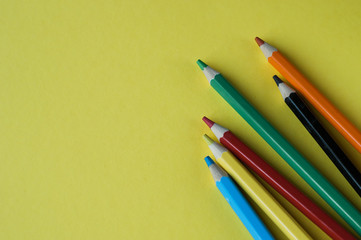 Circle of colour pencils on black background.Close up. Many different colored pencils on dark purple background.Colorful pencil.