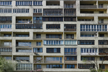 Fototapeta premium Balconies and windows of a multi-storey apartment building. Old Soviet high-rise building with balconies. City background.