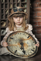 little girl in a dress sitting on the floor with a vintage clock