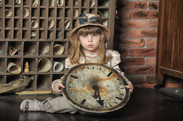 little girl in a dress sitting on the floor with a vintage clock
