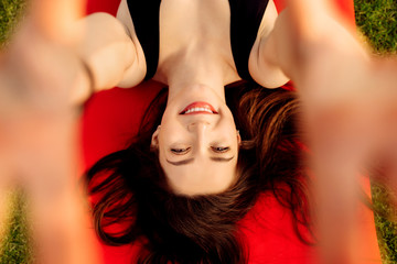Naklejka premium Pretty young woman smile to the camera lying on a sports mat