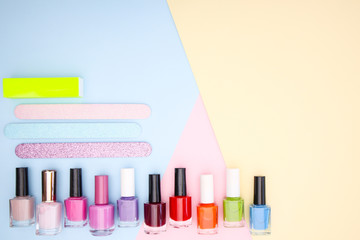 Nail accessories, nail polishes on colorful background 