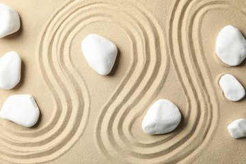 Fototapeta na wymiar Stones on the sand with patterns. Zen concept
