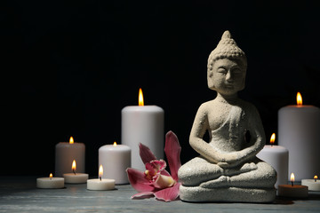 Composition with buddha and candles on wooden table. Zen concept