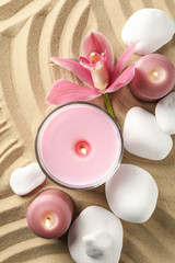 Candles and stones on sand background, top view. Zen concept