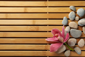 Stones and orchid on bamboo background. Zen concept