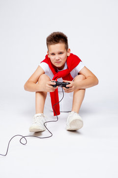 a teenager emotionally plays a computer or console game using the joystick.